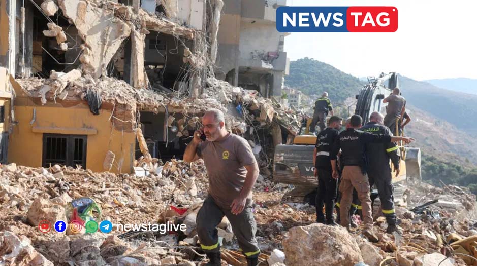 Lebanese civil defence members work at a site damaged in an Israeli air strike in Barja